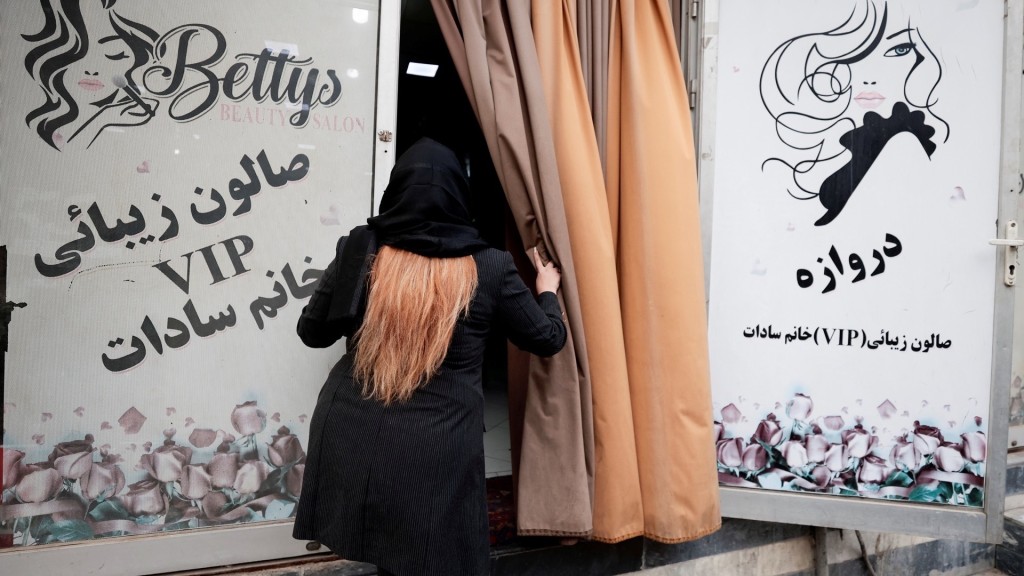 2021年10月，塔利班從新上台後美容院繼續營業，一名老闆娘走進店裏。  路透社