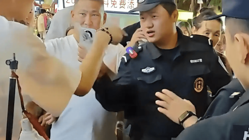 女子疑因未付款刮中百萬大獎遭攤主奪票,民警到場處理。 女子疑因未付款刮中百萬大獎遭攤主奪票,民警到場處理。