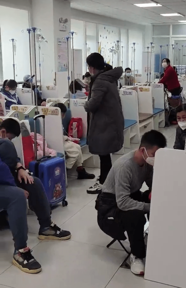 不少病童坐在家長自備的折疊椅上，在醫院走廊輸液。