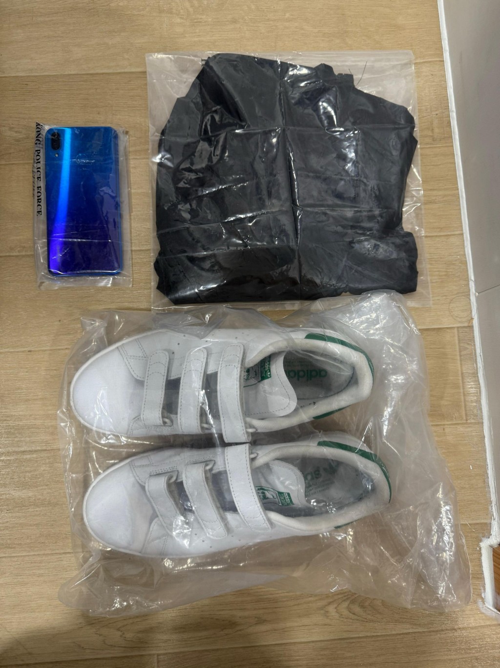 警方檢獲疑犯犯案時身穿的衣物及手提電話。警方圖片