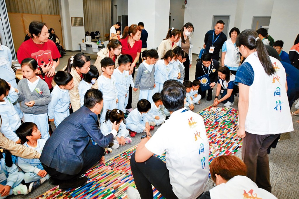 義工合力組裝玩具積木輪椅斜台。