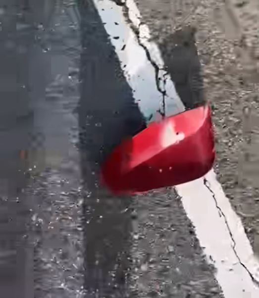 拍片者将镜头移向一部红色七人车，可见七人车倒后镜损毁。网上片段