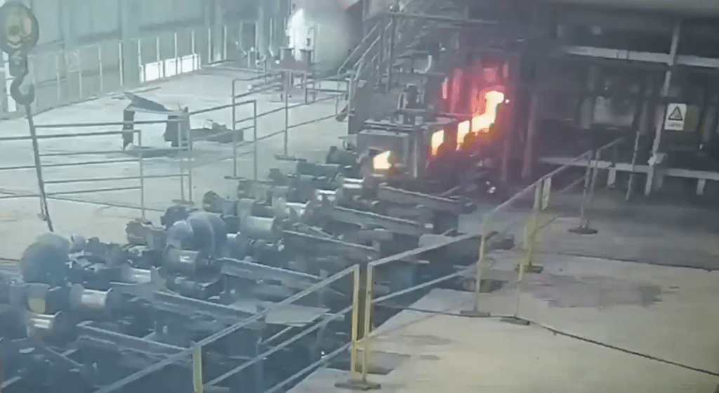 中国一处钢铁厂一名工人正专心地在整理设备。