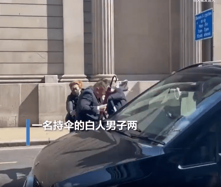 外籍男子在马路上向示威者挥舞雨伞。网上影片截图
