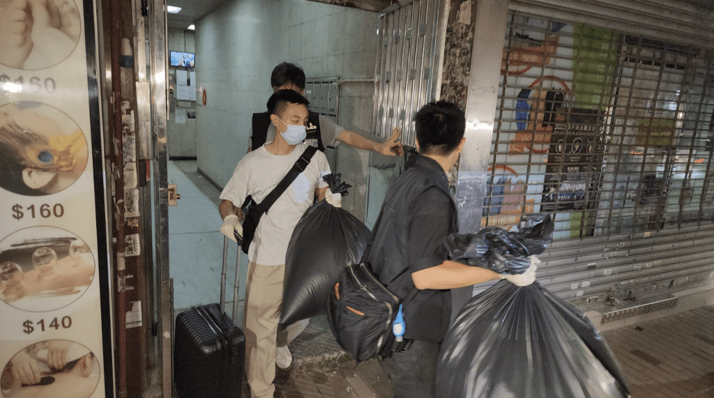 警方晚上從案發單位取走多袋證物。黎志偉攝 警方晚上從案發單位取走多袋證物。黎志偉攝