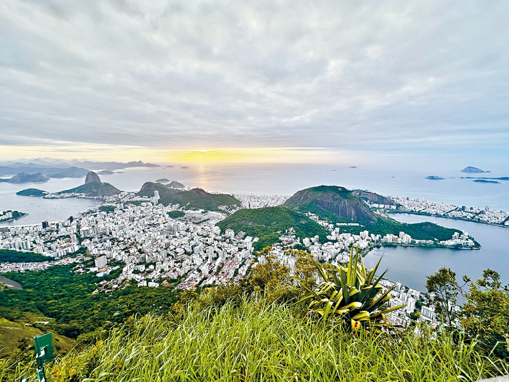 從Mount Corcovado山峰俯瞰里約熱內盧山海交融的優美日出景致。