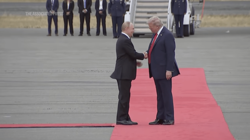 特朗普與普京微笑握手,有說有笑。美聯社畫面截圖 特朗普與普京微笑握手,有說有笑。美聯社畫面截圖