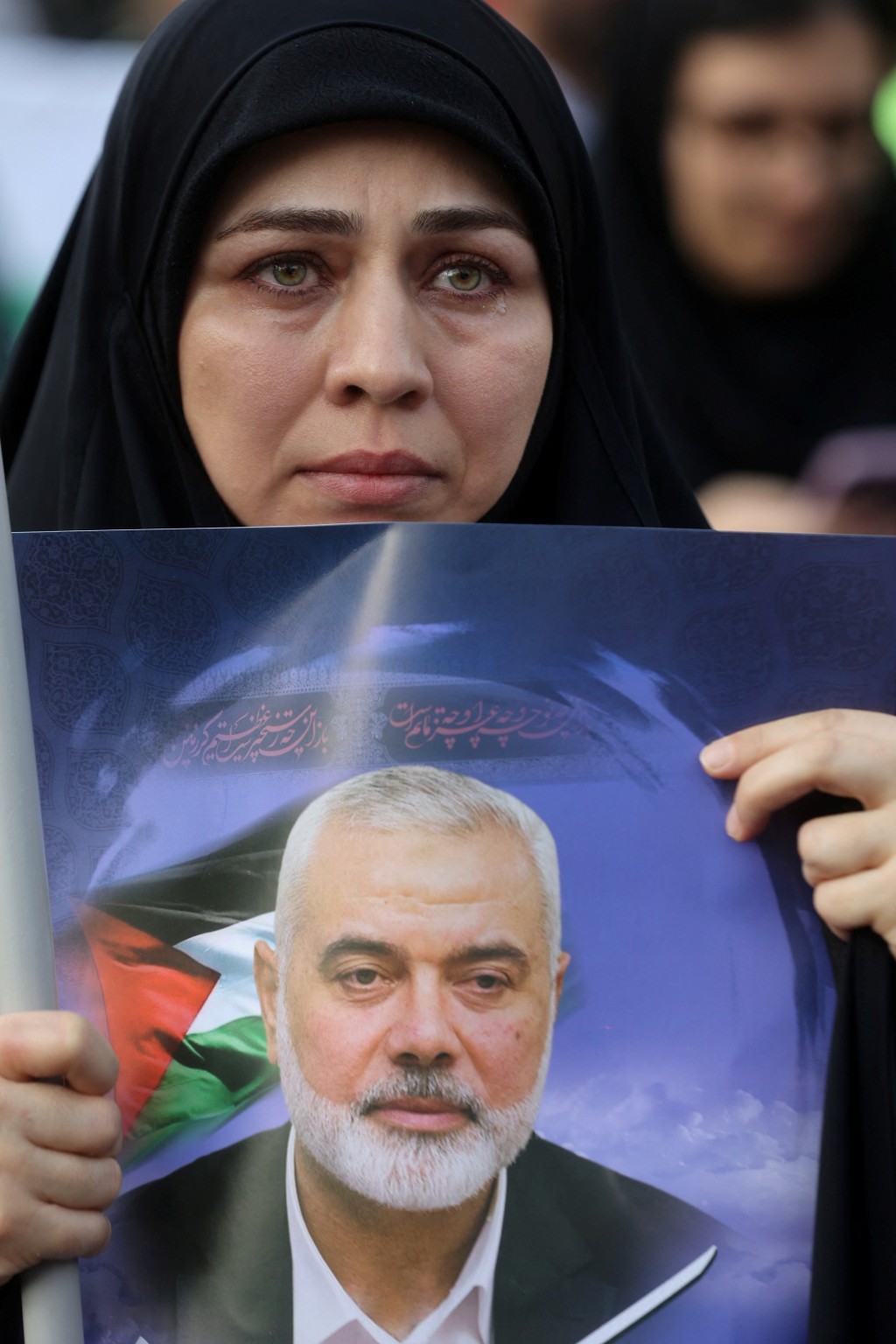 德黑兰有示威者手持哈尼亚肖像抗议他遇害。路透社