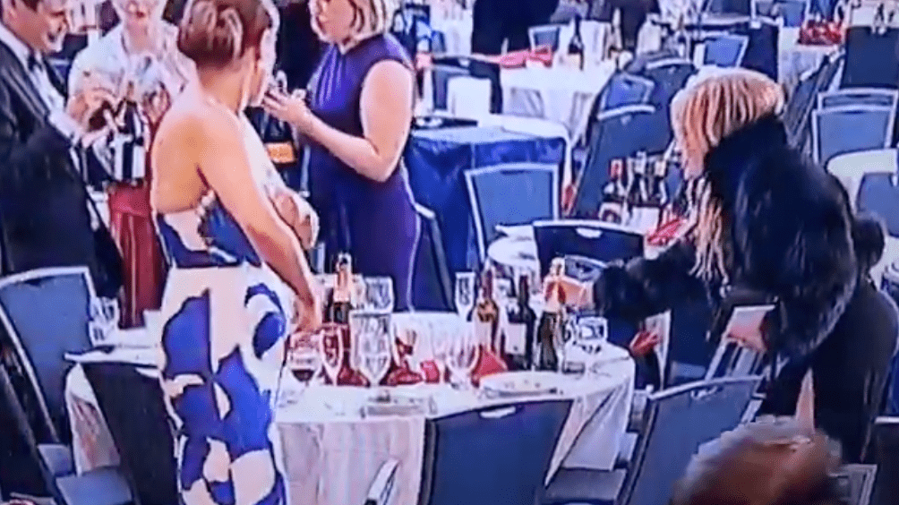 女賓客「順手牽羊」先從餐桌上拿走一瓶香檳。