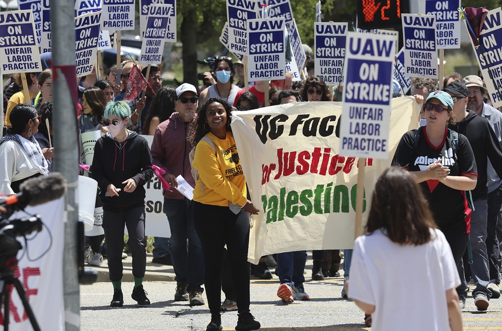 加州大学圣克鲁斯分校罢工教职员罢工举起各式标语牌。美联社