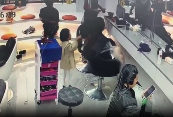 女童拿剪刀剪了一顧客的長髮。