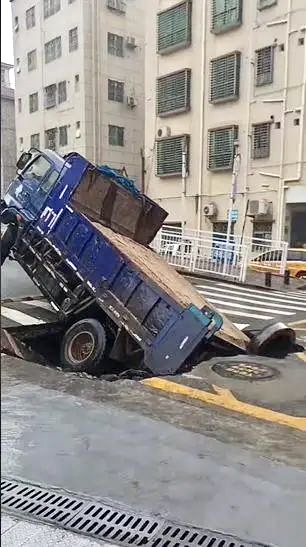 運沙車在深圳寶安區遇路陷，後輪墮坑。