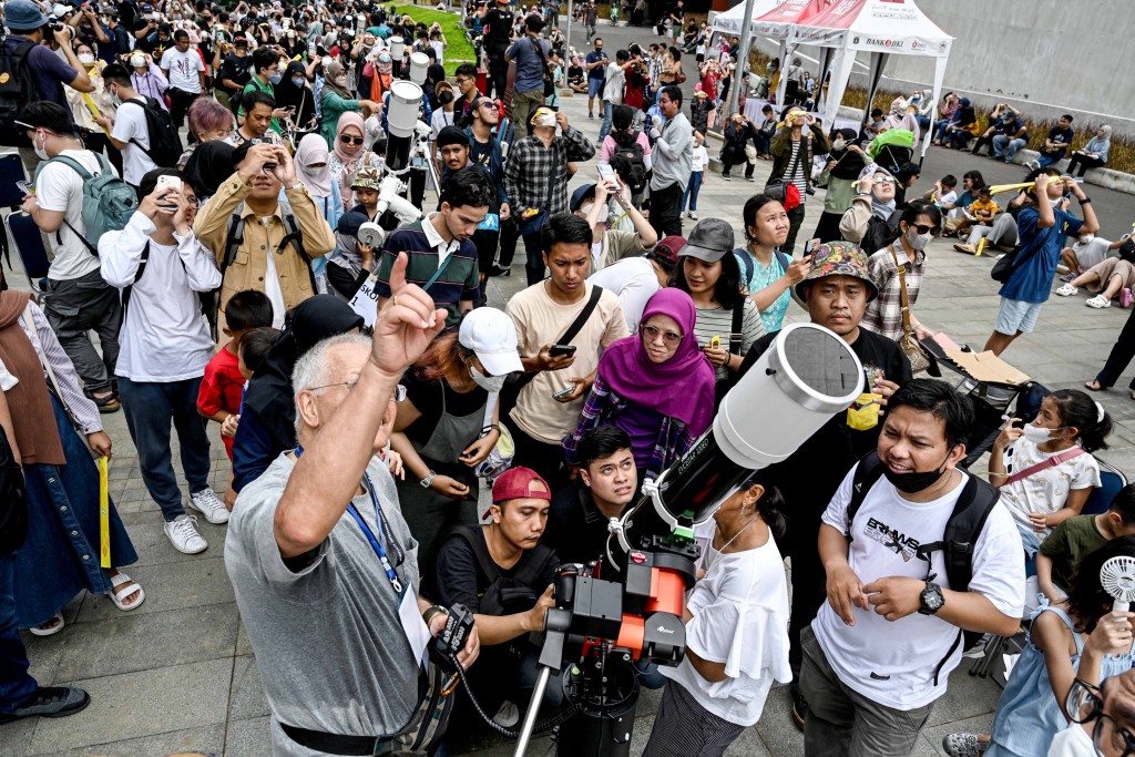 印尼民众在户外观看日全环食的现象。（新华社）
