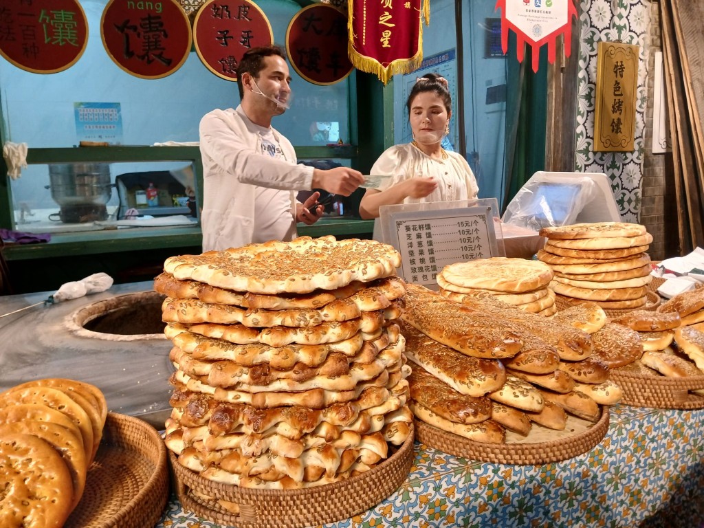 食街桌上满满叠叠的新疆烤饢。