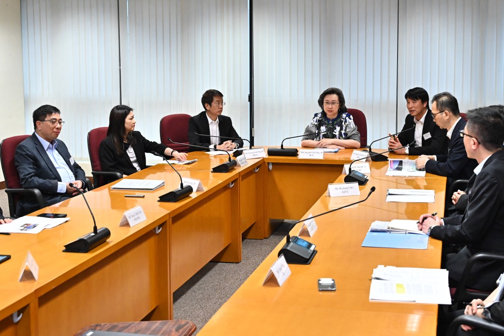 示杨何蓓茵（左四）听取路政署署长陈派明（左五）和其他首长级人员简介该署的最新发展。