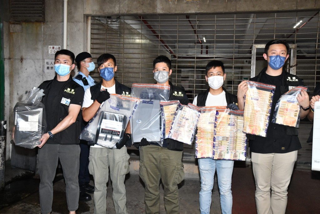 警方撿走一批電腦、電話和現金。徐裕民攝