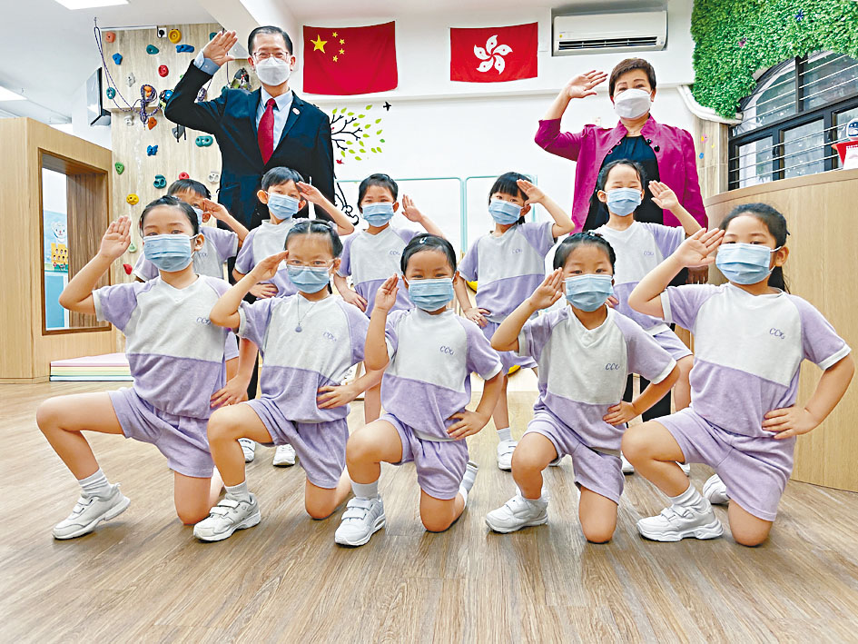 校長林翠玲(後排右)指,教材有助培養學生守法愛國意識。旁為湯修齊。