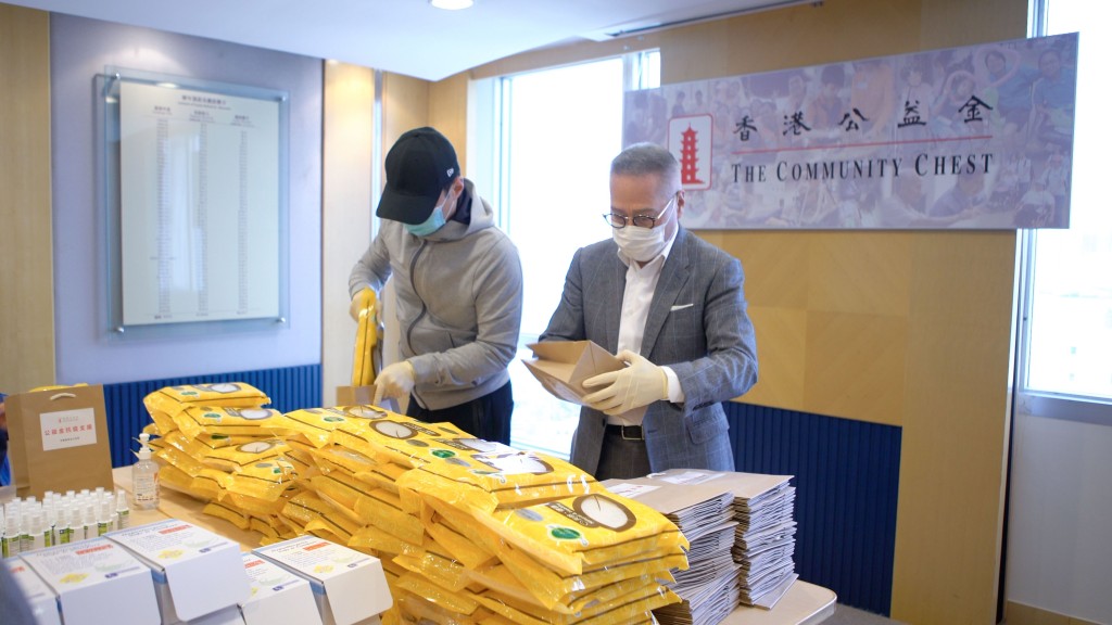 黎明(左)與郭少明親自為防疫物品包裝。