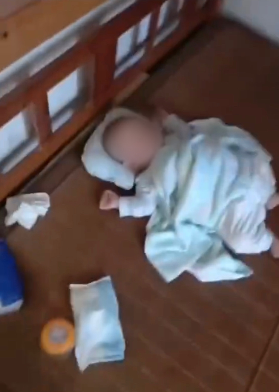 婴儿原本在床上睡觉，被男子吵醒惊跳了一下。