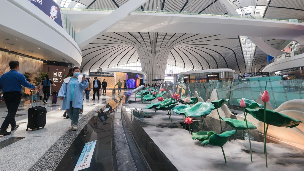 北京大興國際機場內一組名為「荷顔悅色」的藝術景觀吸引旅客打卡拍照。 中新社
