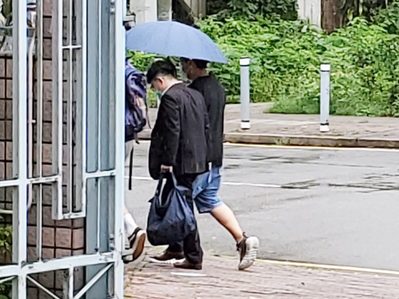 黃俊迪 (右圖西裝手持藍色袋)。資料圖片