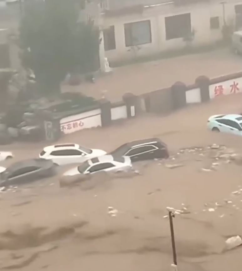北京暴雨困，門頭溝大量汽車被沖走。