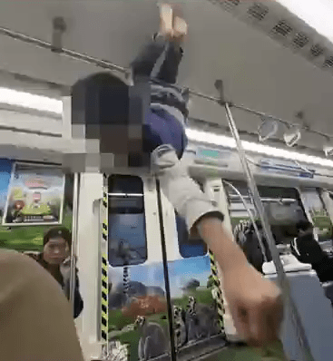 男童在地鐵車廂內，倒掛在扶手上，非常危險。  網片截圖