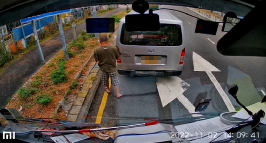 該司機一邊察看罰單內容，一邊走到路旁。Lai Yiu Kuen影片擷圖