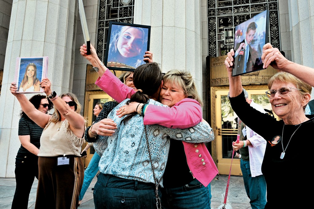 洛杉矶高等法院周三就社媒成愈案裁决后，一批母亲在法院外举起据称受同类伤害的孩子的照片，庆祝原告胜利。 