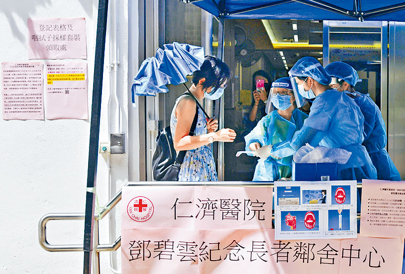 石硤尾邨內仁濟醫院鄧碧雲紀念長者鄰舍中心外，市民領取咽喉拭子採樣套裝。