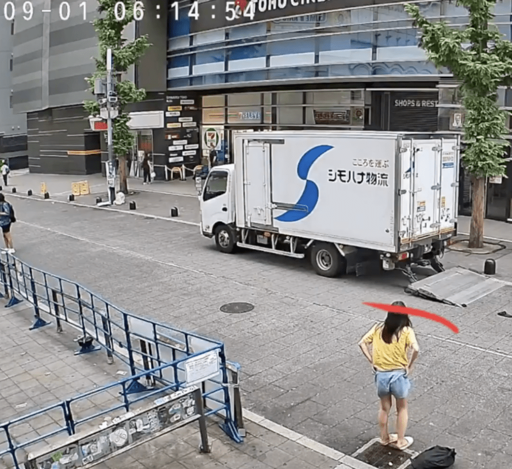 路电视画面所见，一名身穿黄色上衣及牛仔短裤的长发女子走到路旁排水渠盖，然后开始褪下衣物。X@Amelia181672271