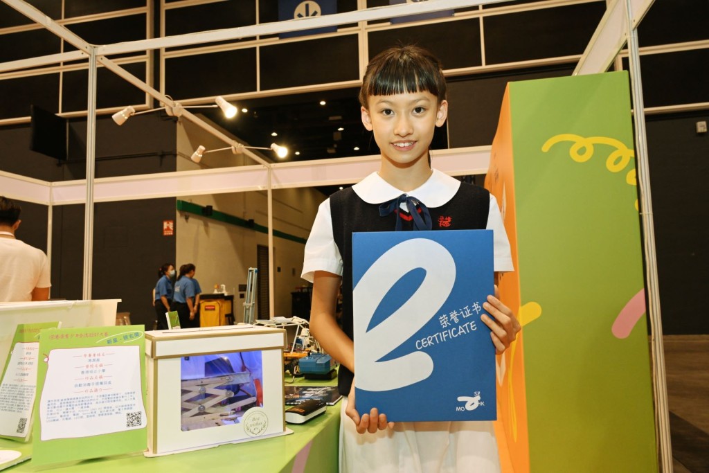 香港培正小學馮潔盈和她設計的自動消毒手提電話盒。