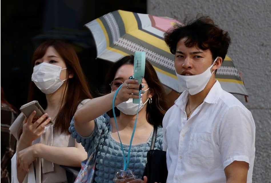 东京街头热爆市民手执迷你风扇降温。路透社