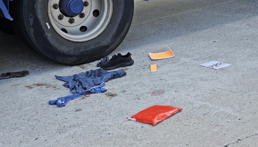 貨櫃車車輪旁邊遺下一隻鞋。 貨櫃車車輪旁邊遺下一隻鞋。