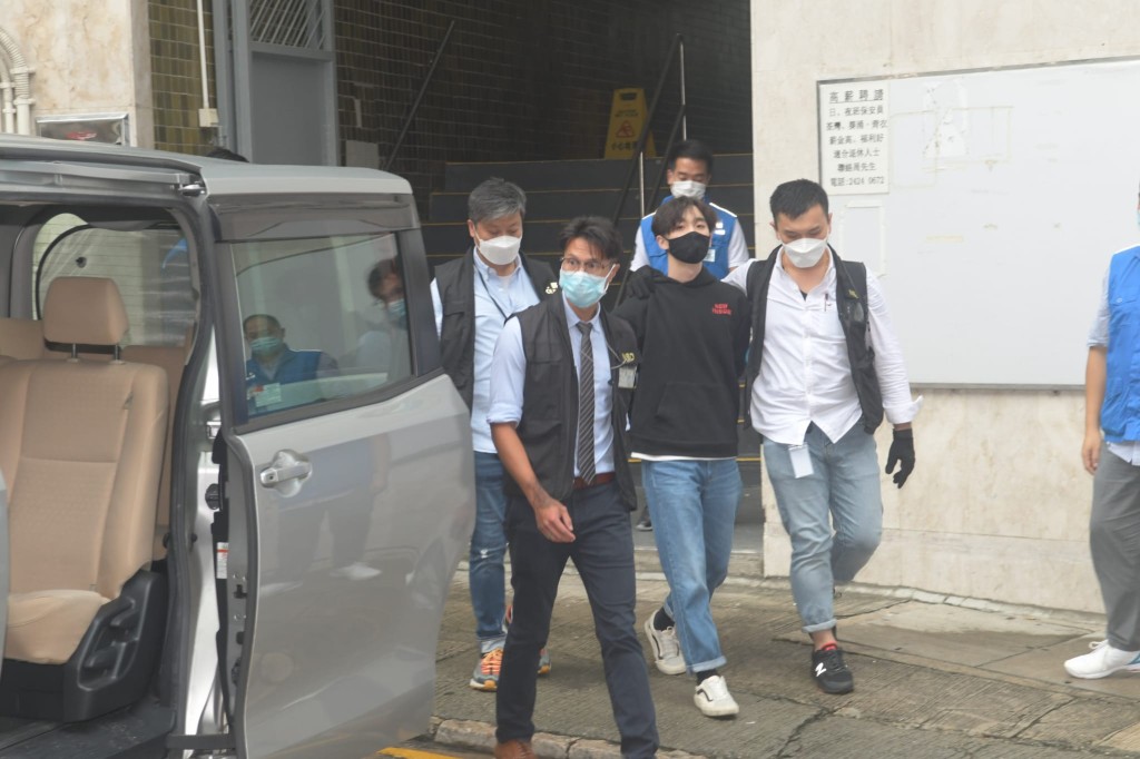 警方在華星工業大廈拘捕王逸戰（黑口罩）。