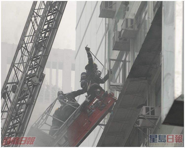 消防員用鐵筆破窗,疏導充斥大廈內濃煙,並搶救被困住客。資料圖片