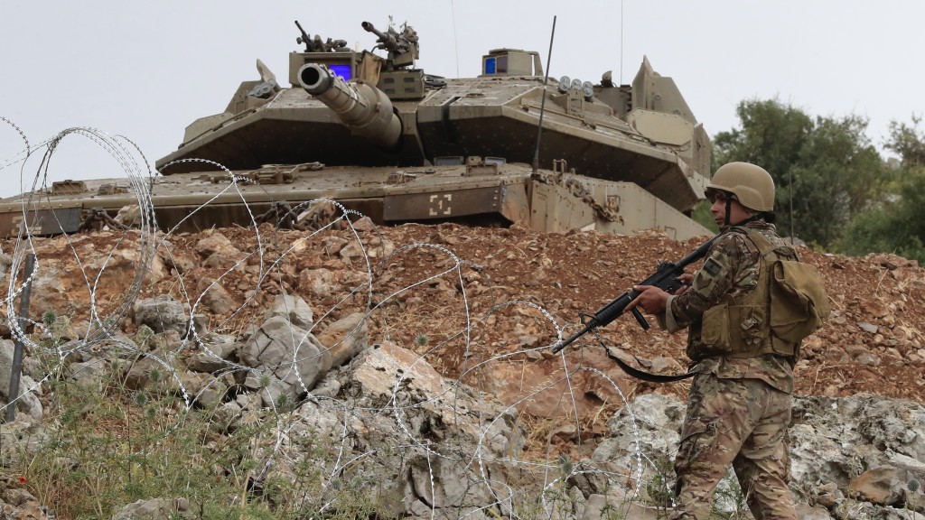 在黎巴嫩南部边境有争议的卡法乔巴山上，一名黎巴嫩士兵站在以色列梅卡瓦坦克前。 美联社