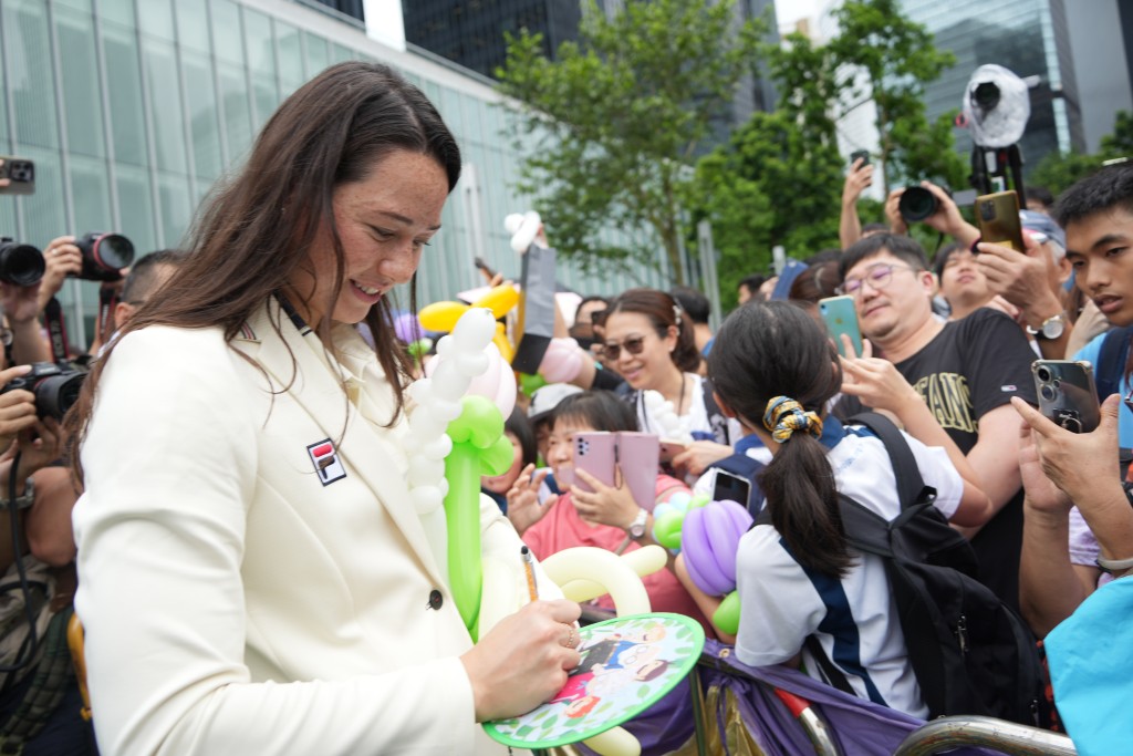 运动员为市民签名合照留念。吴艳玲摄