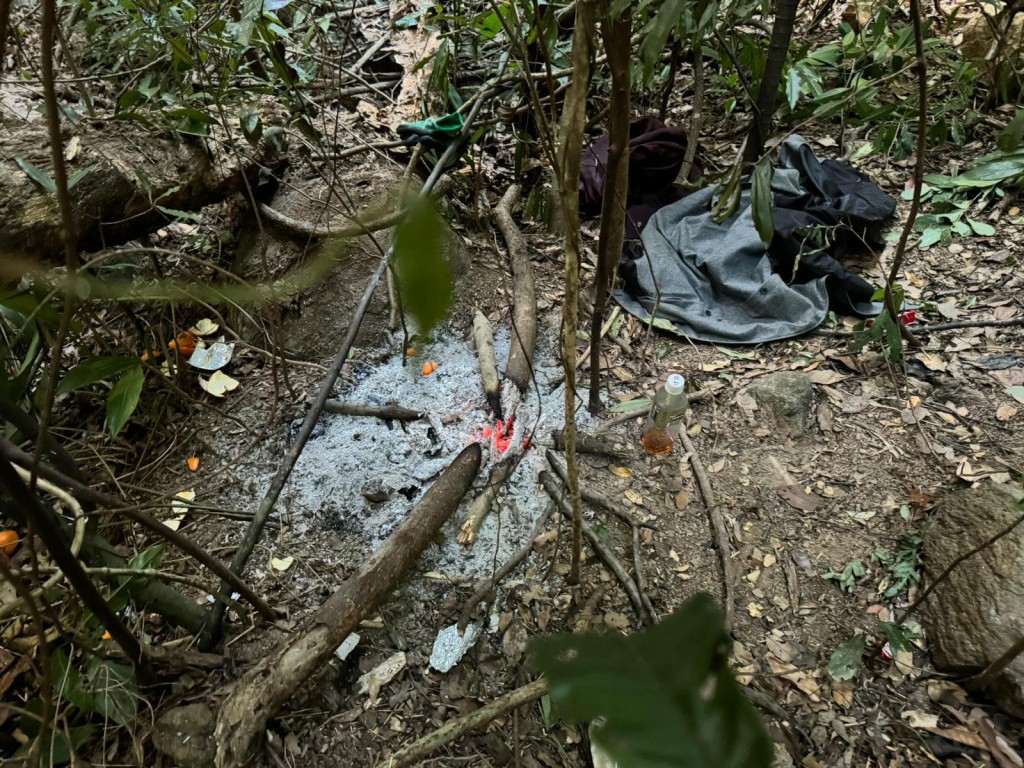 警方在山坡叢林內發現一個燃燒中的火堆及懷疑匪徒的衣物。警方提供