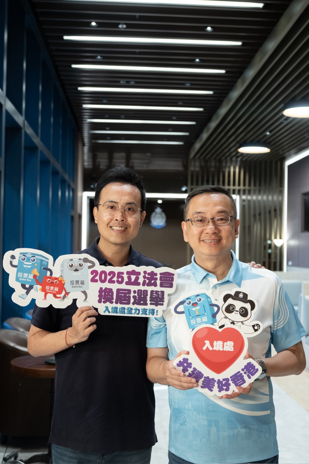 入境处处长郭俊峯（右）邀请香港台球运动员傅家俊（左）拍片宣传立法会选举日。入境处提供