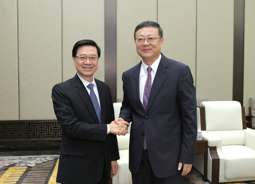 李家超（左）与陈吉宁（右）在会面前握手。政府新闻处图片