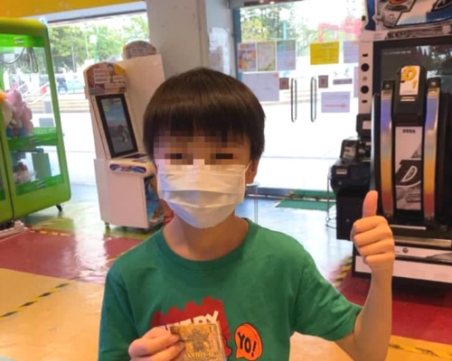 男童獲贈超人卡後重現笑容。「萬家歡兒童場」圖片