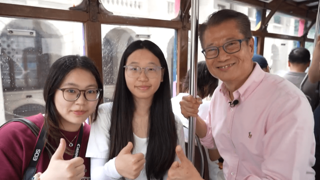 陳茂波在電車上與市民遊客傾談。影片截圖