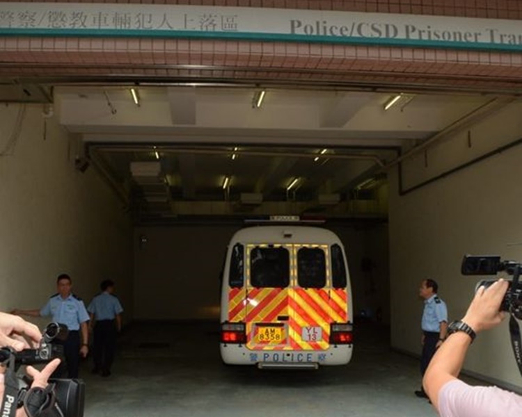 兩名被告由警車押上法院。