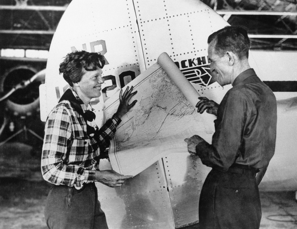 埃爾哈特（左）與她的導航員努南對着地圖討論飛越太平洋的計劃。 美聯社