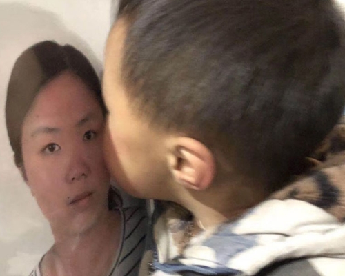 兒子葬禮中親吻媽媽的遺照。(網圖)
