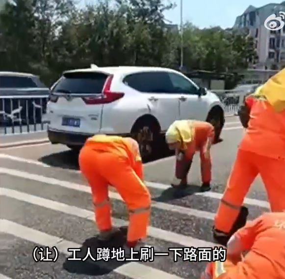 大连环卫工人烈日下擦洗马路斑马线。