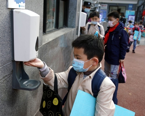 上海市中小學開學學生嚴守防疫消毒。新華社