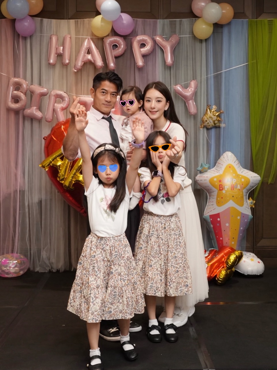郭富城與方媛抱着幼女，與兩名活潑高舉愛心手勢的女兒在粉色氣球佈置前留下溫馨的五口全家福。