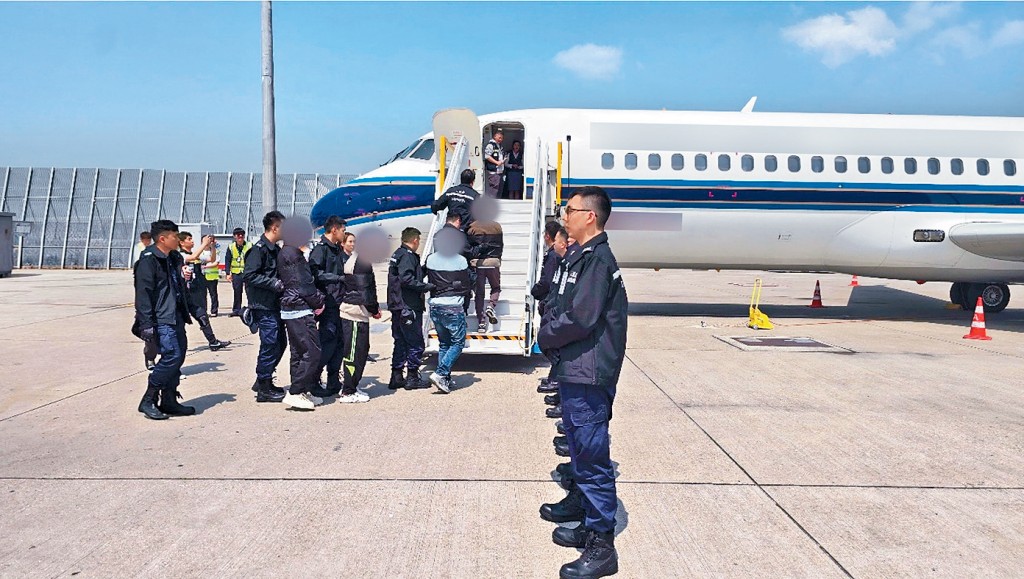 被遣返人士在入境處人員押送下登機離港。